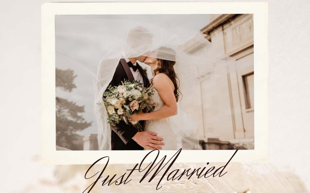 A newlywed couple shares a kiss under a veil, holding a bouquet - ribeirodesousa.com